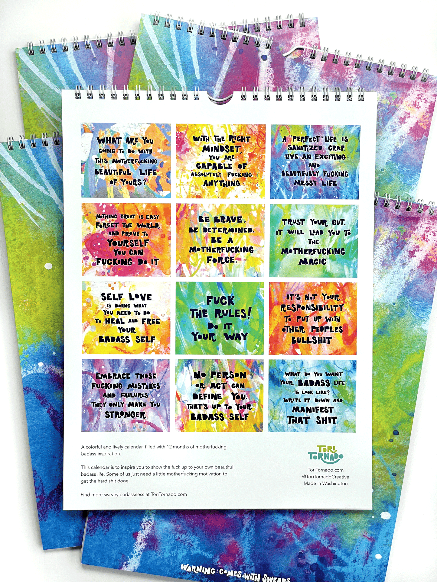 Colorful spiral-bound notebook with motivational quotes on a white background